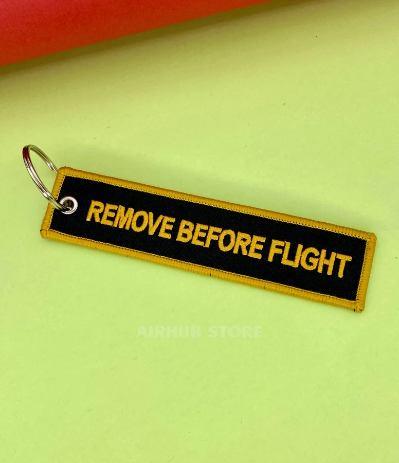 Remove Before Flight black and orange Keychain